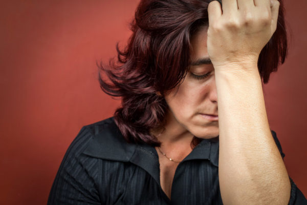 woman with a headache holding her hand to her forehead